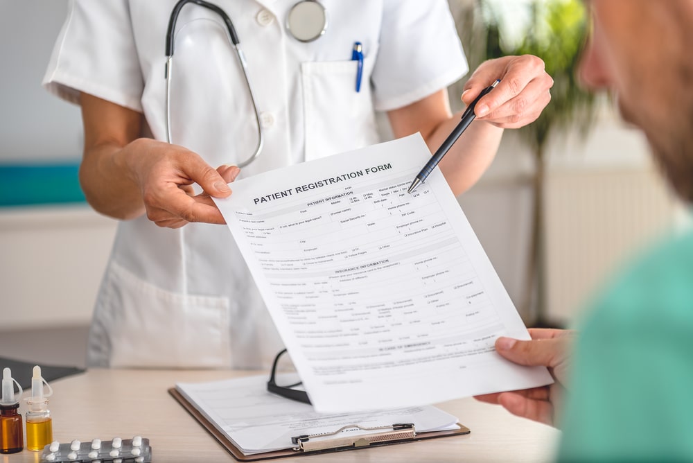 Doctor receiving patient registration form in hospital